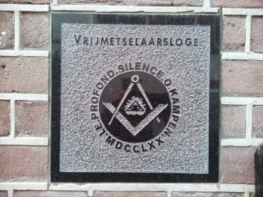 Vrijmetselaarsloge in steen met letters en symboliek