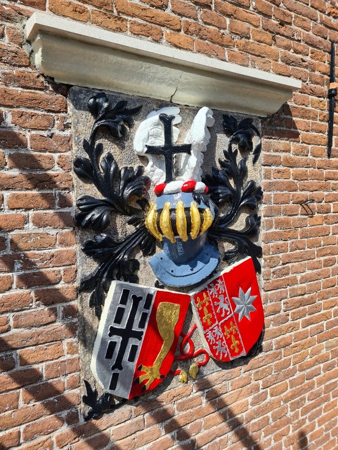 Gevelsteen na restauratie met herstelde kleuren en wapens